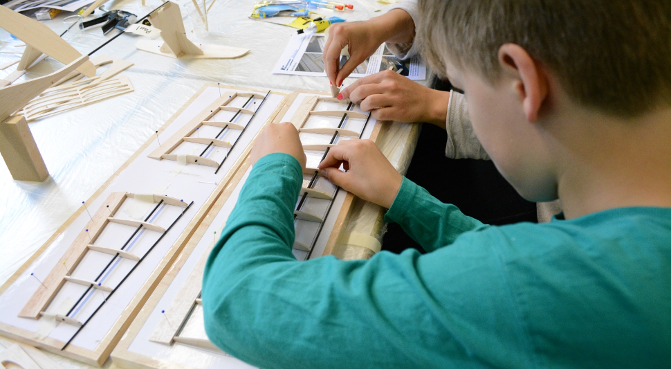 Schüler baut am Flügel des Segelfliegers.
